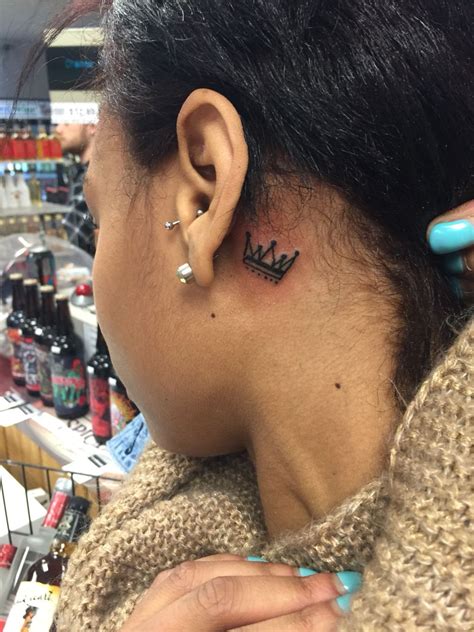 crown tattoo behind ear meaning.